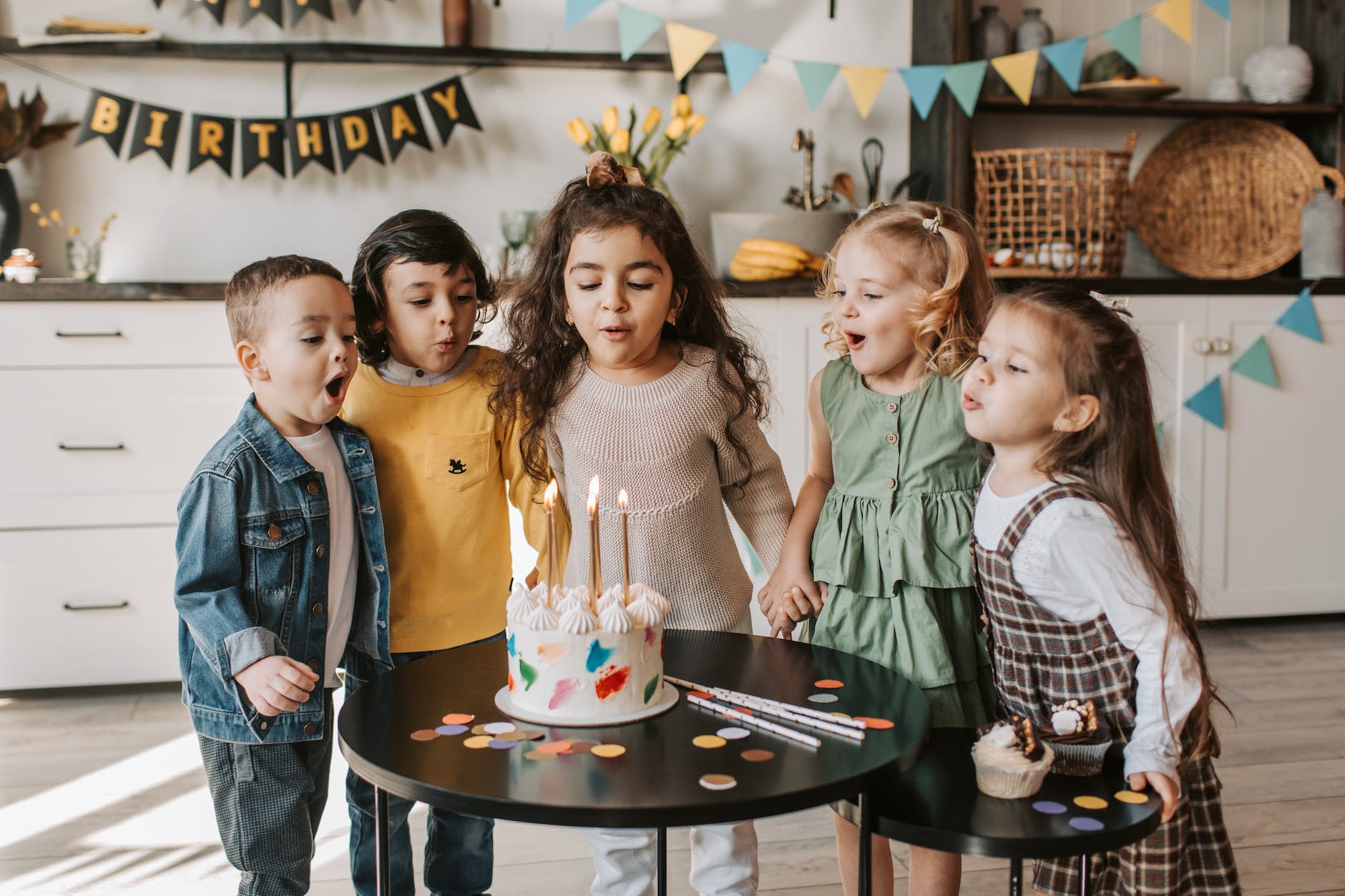 kids blowing candles on a cake